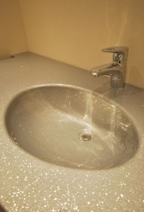SIlver sparkly bathroom countertop and built in basin.