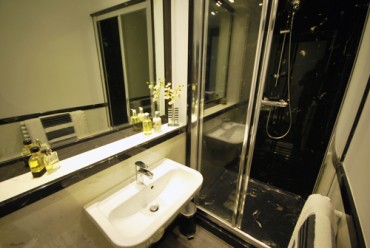 Shower and sink area of bathroom in black and white style