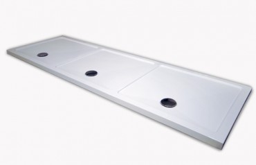 Multiple shower area shower tray with 3 chrome wastes in white.