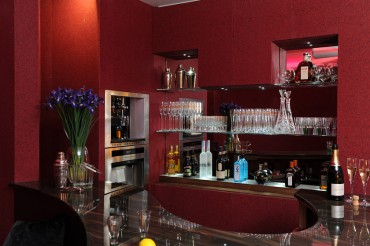 Bar area with red wallpaper, brown marble shaped bar top.