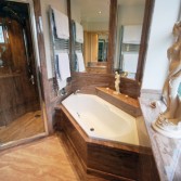 Luxury bathroom with large walk in shower, diamond shape bath and mirrors in granite.