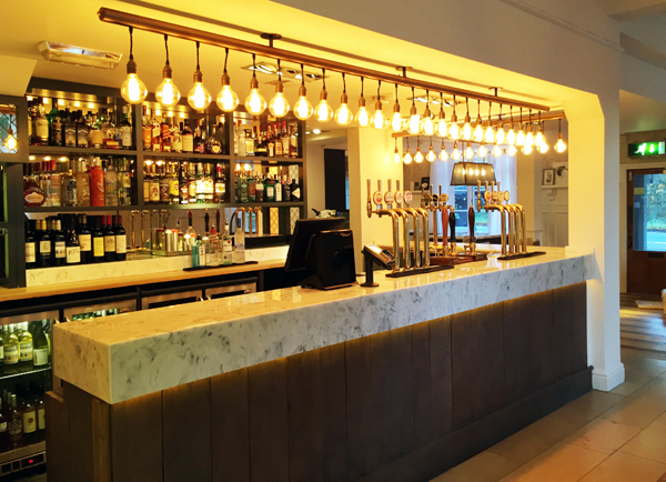 Modern bar design with feature light bulbs and marble bar top