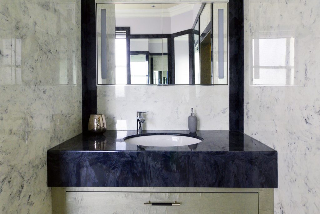 Dark grey marble vanity top from versital with an undermounted sink and a sycamore under sink cabinet