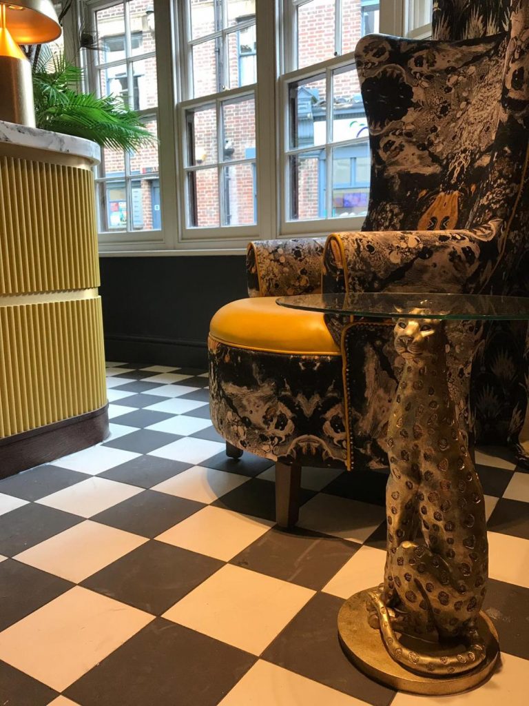 Black and yellow themed waiting area with gold leopard side table